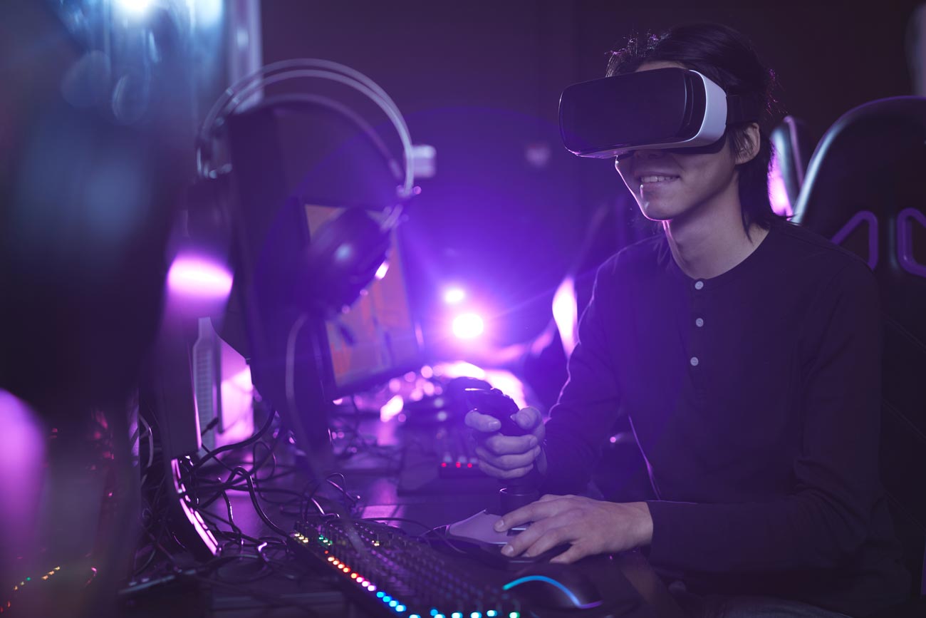 side view portrait young asian man wearing vr headset while playing video games using racing shift dark cyber interior copy space
