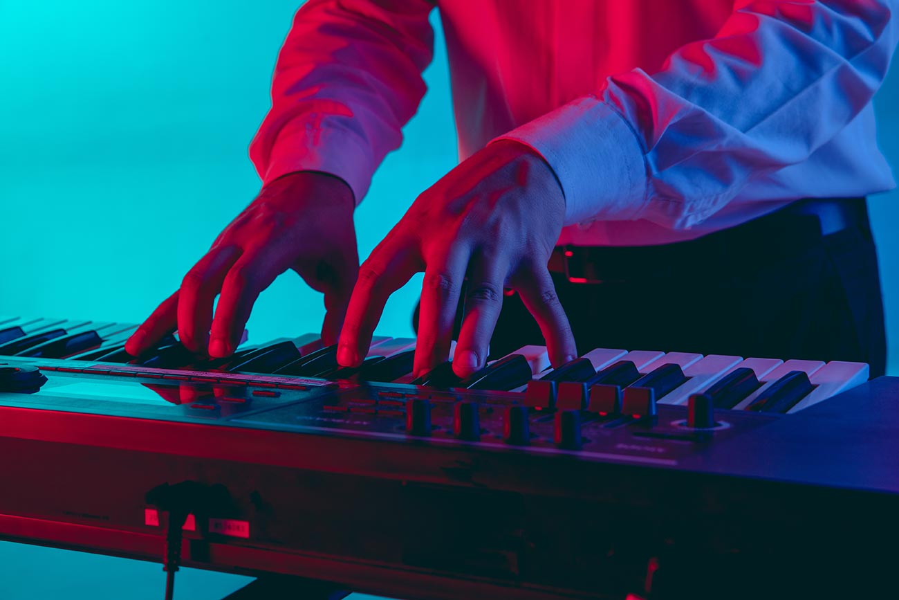 young caucasian musician keyboardist playing gradient space neon light concept music hobby festival